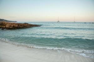 hermosa playa con agua muy limpia y azul en el mar mediterráneo en la isla de ibiza, españa. foto