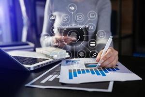 Hands of woman using mobile phone in modern office with laptop and digital tablet computer with VR icon photo