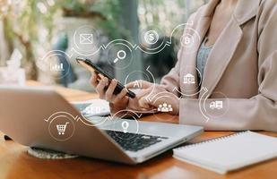 businesswoman or Designer using mobile phone with laptop and digital tablet laptop and document on desk in office with virtual icons network diagram photo