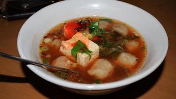 Tofu and meatballs served with gravy, with additional spicy sauce and soy sauce photo