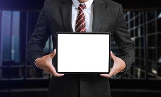 Business man holding and shows touch screen tablet with digital device, technology photo