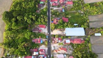 vista aérea olhe para baixo o sol brilha na estrada perto da vila de malaios video