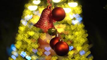 bola de navidad roja y campana ondeando en el árbol de navidad de amor video