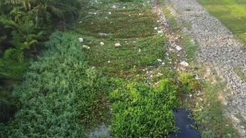 Fly over garbage dump on river. video