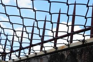 Electrical wire and spikes on prison walls photo