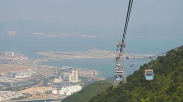 Teleférico de ngong ping con el aeropuerto chek lap kok en segundo plano. video