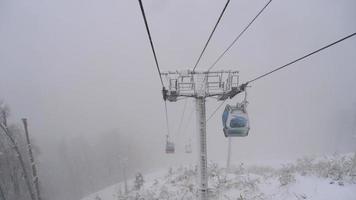 View from cable car gondola moving through heavy snowfall. video