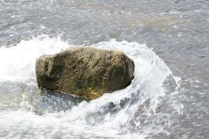 stone that was hit by water in a stream photo