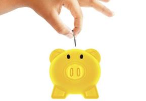 Saving money by putting coin into piggy gold bank photo