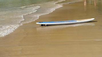 prancha de surf na praia de areia tropical vazia. video