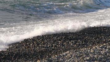 olas del mar rodando hacia la playa de guijarros video