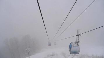 vista dalla cabinovia della funivia che si muove attraverso forti nevicate. video