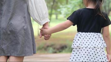 Mother holding daughter's hand in outdoor spring garden. family relationship concept video