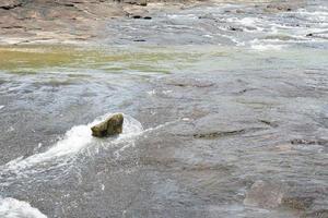 stone that was hit by water in a stream photo