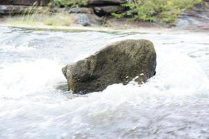 stone that was hit by water in a stream photo