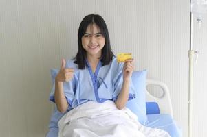 A young patient woman is holding credit card , admitting in hospital , Health care  concept photo