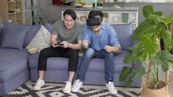 Young smiling gay couple playing video games in the living room at home, LGBTQ and diversity photo