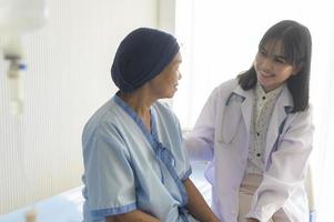 médico sosteniendo la mano de un paciente con cáncer en el hospital, atención médica y concepto médico foto