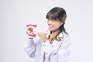 Una joven dentista sonriendo sobre un estudio de fondo blanco foto