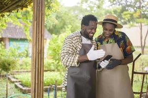 feliz pareja de agrónomos negros disfrutando y trabajando en tierras de cultivo, concepto de agricultura foto