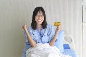 A young patient woman is holding credit card , admitting in hospital , Health care  concept photo