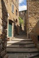 un callejón en el centro histórico de campiglia marittima livorno toscana con una escalera de piedra foto