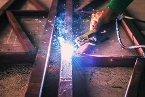 close up hand welding steel with spark photo