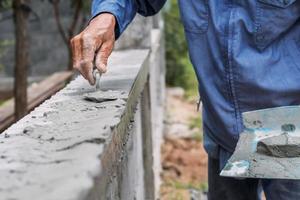 la mano de primer plano del trabajador está enyesando foto