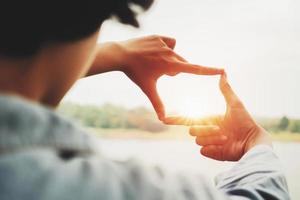 hand framing view distant over sunset. business concept photo