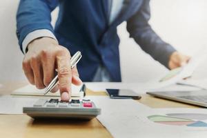 businessman working on desk and using calculator in office photo