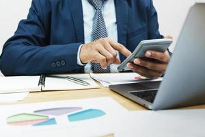 businessman working on desk and using calculator in office photo