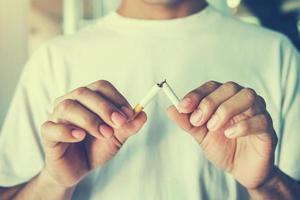 closeup hand broken cigarette. concept stop smoking photo