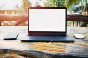 laptop computer blank white screen and mobile on table in cafe background photo
