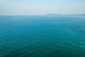 vistas al mar e islas rocosas con un bote de cola larga. foto