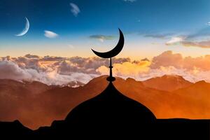 Crescent moon of Muslim mosque on sky background. Symbol of Islam on dome of mosque. Silhouettes of Islamic baths and minarets. Concept - belief in Islam and Islam. Visiting mosques photo