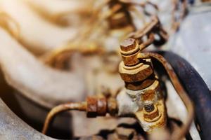 Old Rustic knot and rusty iron chains knotted with sunlight on engine of motor car photo