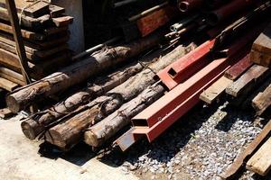 tubería de acero y metal. tubería de soldadura, acero aleado, madera y poste de madera en el sitio de construcción foto