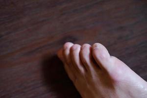 Closed up female feet with french nails on wood floor, Healthy care and medical concept photo