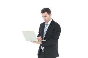 hombre de negocios exitoso y guapo en un traje sonriendo con la mano sujetando el cuaderno. se toma en serio trabajar en un portátil aislado de fondo blanco. copie el espacio foto