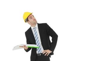 Handsome and smart engineer or architecture in black suit Wearing a yellow safety engineer hat with hand holding construction drawing papers and serious in work isolated on yellow background. photo