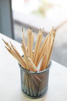 Close-up many brown pencils are in steel box on desk in medern office photo