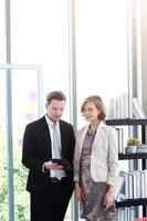 Successful businessman and businesswoman meeting and hand holding laptop for good ideas in modern office photo