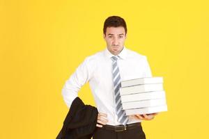 Handsome and smart businessman in suit and white shirthand holding document books isolated on yellow background. Copy Space photo