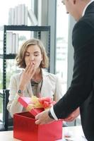 Businessman surprise and give red gift box for businesswoman in office for Birthday. Christmas,Happy new year and Valentine's Day concept photo