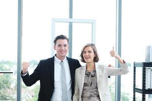 Successful businessman and businesswoman meeting and happy for partnership in modern office photo