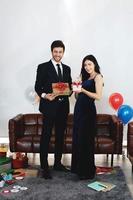 Sweet couple Love happy with surprise gift box girlfriend in christmas time and celebrating new year eve, Valentine day decoration with Christmas tree, colorful balloon and Gift Boxes in pantry Area photo