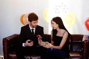 Sweet couple Love smile and spending Romantic christmas time and celebrating new year eve on Brown Sofa decoration with Christmas tree, colorful balloon and Gift Boxes in Living room at home photo