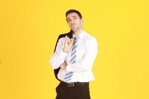 Handsome and smart businessman in suit and white shirt relaxing on isolatred on yellow background. Copy Space photo