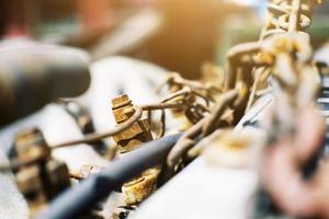 Old Rustic knot and rusty iron chains knotted with sunlight on engine of motor car photo