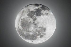 encienda la luz de la súper luna llena en la noche negra oscura y muestre el espacio de textura de la superficie lunar. foto
